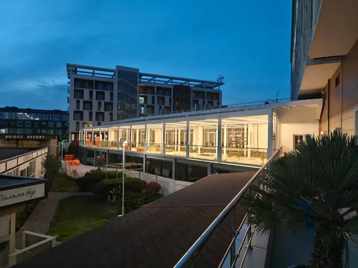Пергола с остеклением вдоль ресторана Bridge Resort в Сириусе вечером